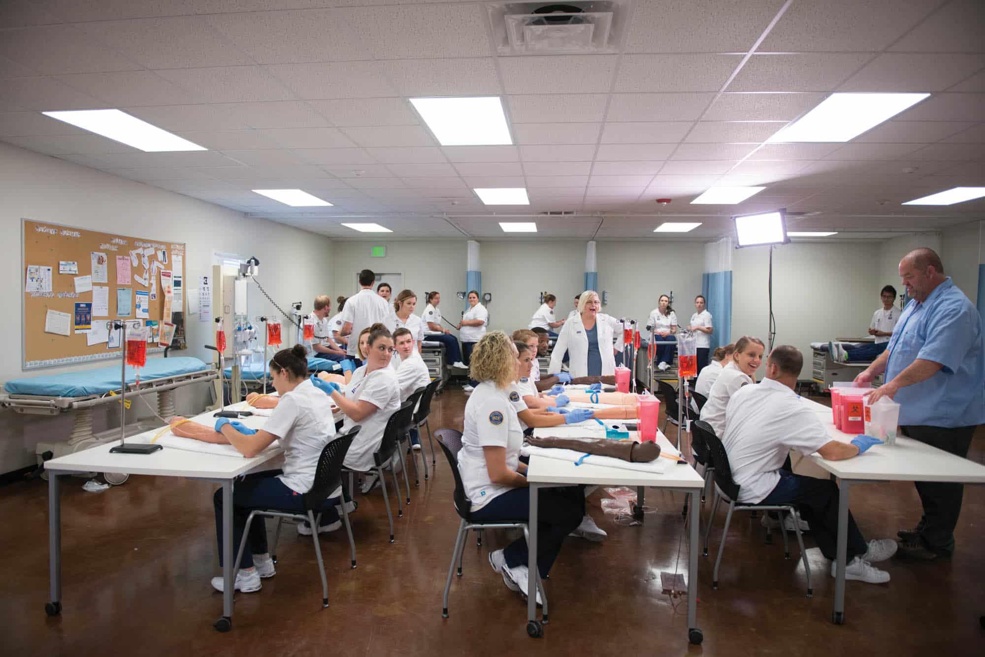A group of nursing student in the classroom performing a procedure.