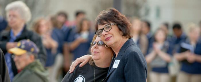 Two women hugging at a veterans vigil.