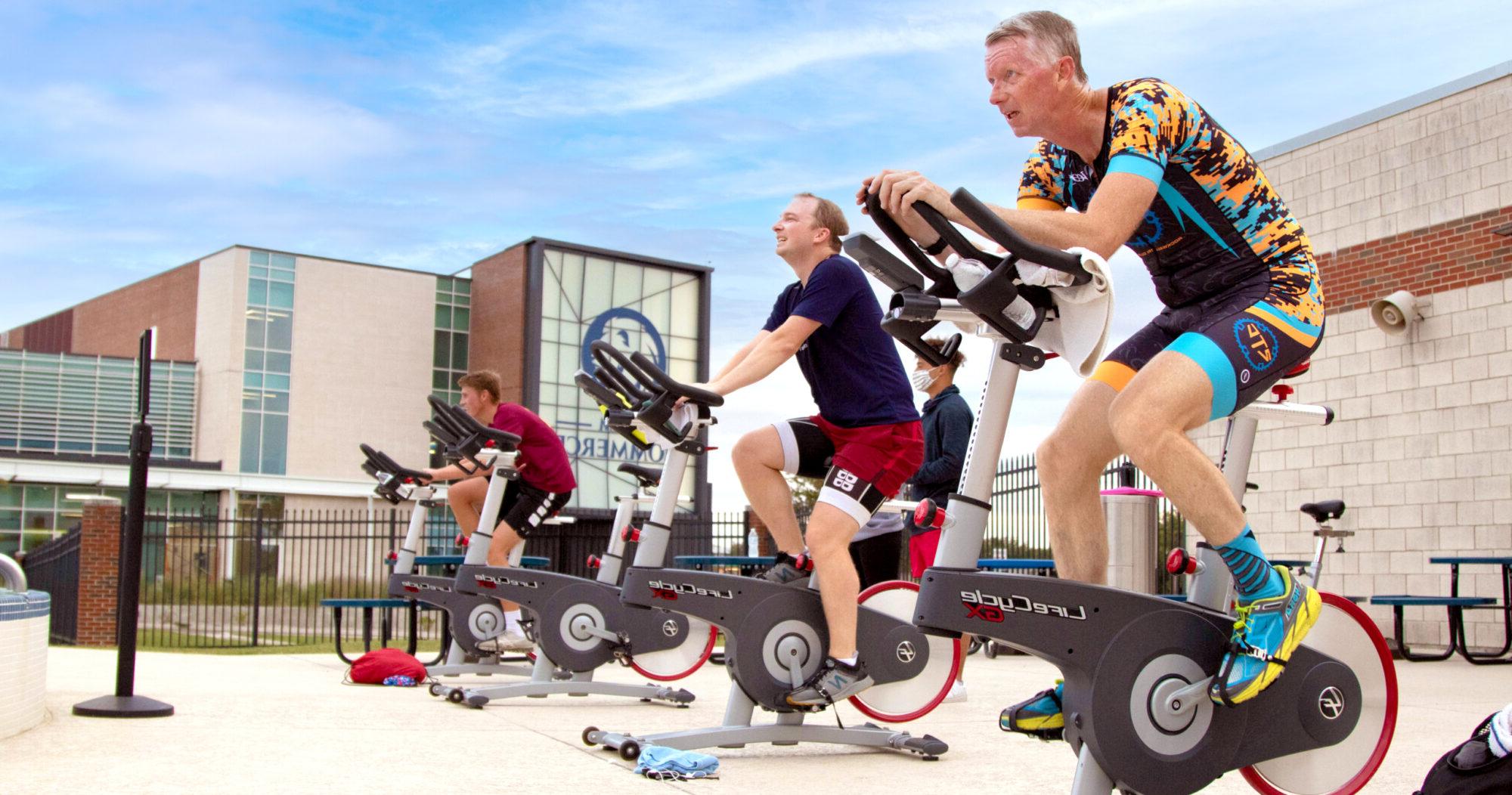 Members during a cycling class by the pool.
